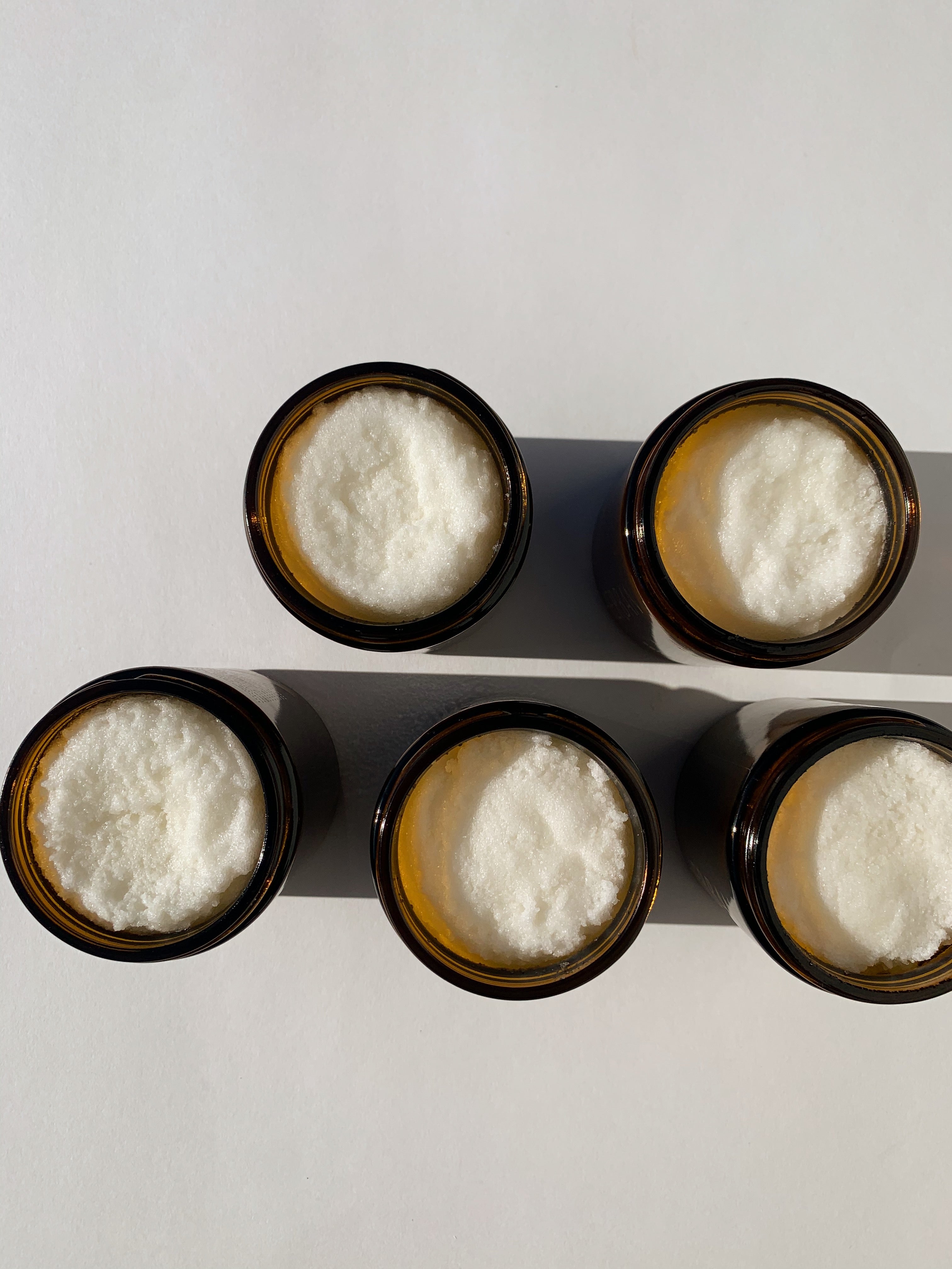 10oz creamy shea butter and sea salt body scrub beautifully packaged in amber glass jars that are printed with gold..
